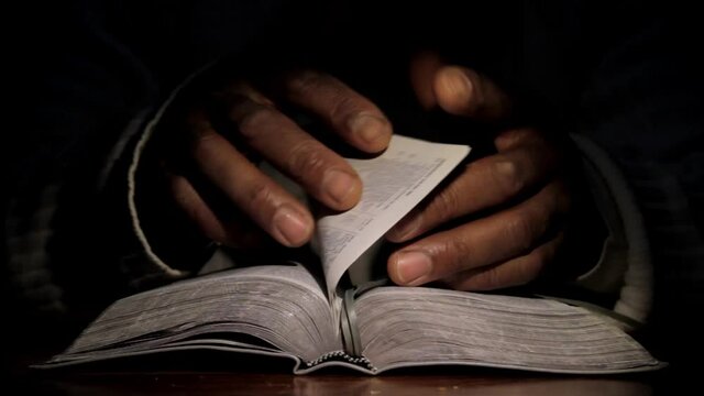 man praying to god with hands on bible praying with black background stock video
