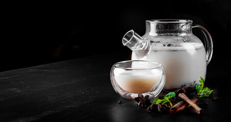 tea pot and Cup of masala tea on black background
