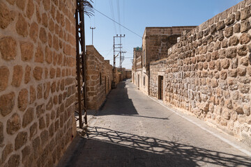 Cobblestone street between stone buildings, Midyat, Mardin, Turkey