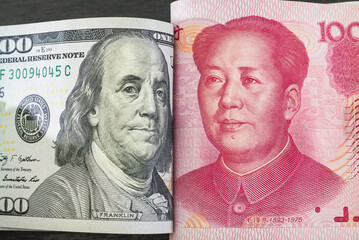 Dollar notes of the US and Chinese yuan rested against each other depicting a confrontation between two economic and political systems. Dollar.