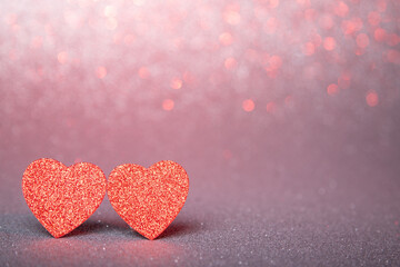 Obraz premium two red hearts in glitter on a silver and red glitter background