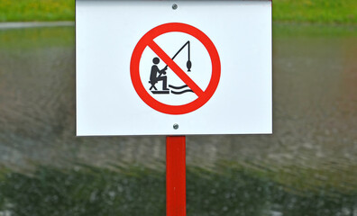 Sign "It is forbidden to fish" against the background of the reservoir