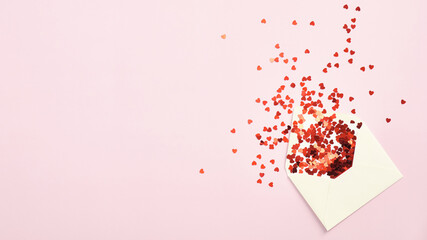 Envelope with red confetti on pink background. Top view with copy space. Valentines Day, Mothers...