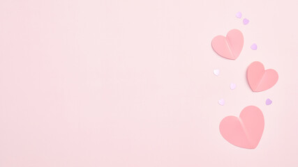 Paper hearts and confetti on pink background with copy space. Valentines Day banner design, Mothers Day greeting card template.