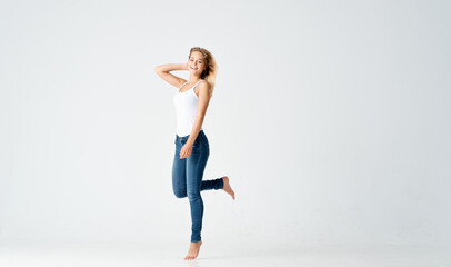 woman jumped up on a light background in full growth sport fitness © SHOTPRIME STUDIO