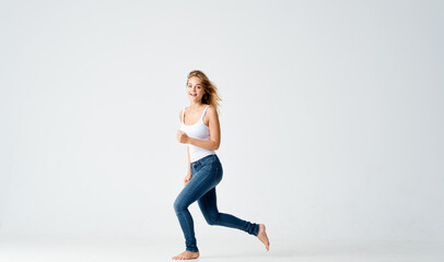 woman jumped up on a light background in full growth sport fitness