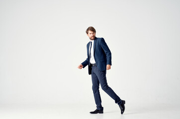 business man in a suit goes to the side on a light background side view Copy Space