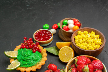 front view yummy cake with fruits and candies on dark background cookies biscuit sweet