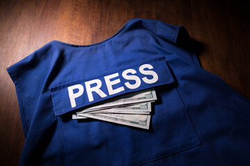Media Journalism fake news concept. Blue journalist (press) vest in dark with backlight and fog. Puppeteer controls media.