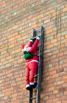Blow up Santa doll climbing a ladder