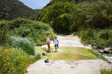 Mother and son crossing a stream