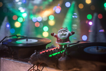 Dj mixer with headphones on dark nightclub background with Christmas tree New Year Eve. Close up...