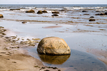 Large stone boulders on the shore of the Gulf of Riga on a summer day.