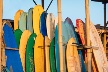 Set of different color surf boards in a stack by ocean.Bali.Indonesia. Surf boards on sandy beach for rent. Surf lessons on Weligama beach, Sri Lanka.