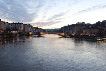 Obraz premium La rivière Saône et ses rives à Lyon au coucher du soleil vus depuis la passerelle du palais de justice, ville de Lyon, département du Rhône, France