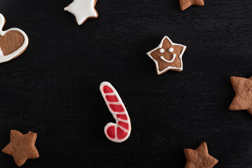 Gingerbread candy cane and stars close up on black background