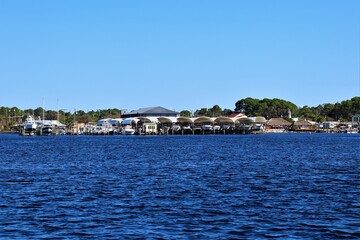 Lakeside marina with boats docked under clear blue sky