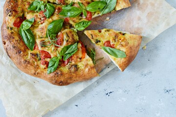 Fresh Italian pizza, focaccia with tomatoes, pesto sauce, garlic and rosemary. National bread. 