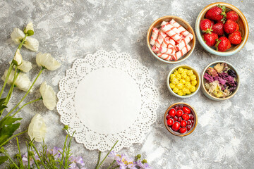 top view fresh red strawberries with candies on the white background berry candy fruit