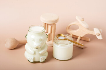 Baby bottles with milk and plane on the wooden table