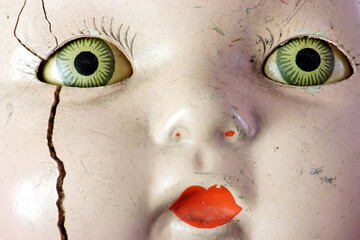 Creepy doll head with spooky green eyes.