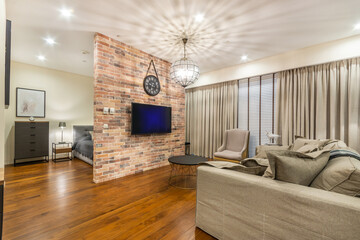 Luxury studio apartment. Living room space. Grey sofa, armchair and a coffee table