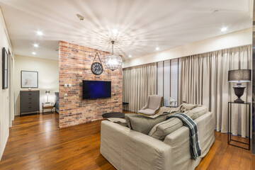 Luxury studio apartment. Living room space. Grey sofa, armchair and a coffee table