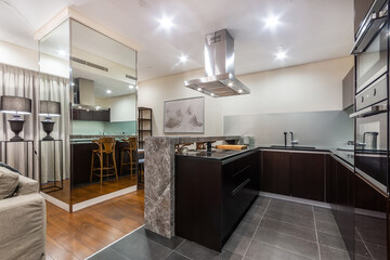 New kitchen with a marble counter, equipped with cooker, oven, fridge