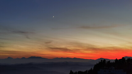 Obraz premium Tramonto sulle montagne, colline e valli dell'Appennino con la luna nel cielo