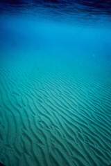 Blue sea with rippled sand