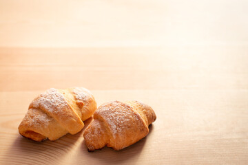 Two fresh tasty coissant cookies on wooden table with copy space. Homemade bakery