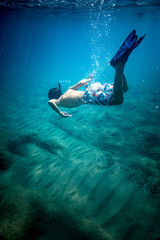 Fototapeta na wymiar Young boy snorkeling underwater