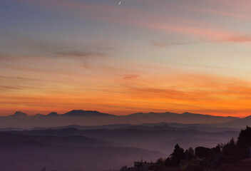 Tramonto sulle montagne, colline e valli dell'Appennino con la luna nel cielo