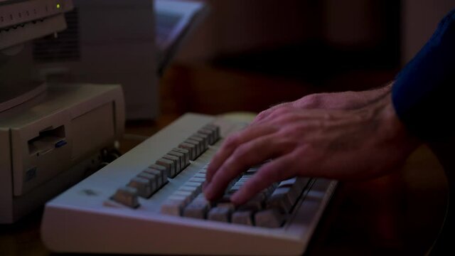 Close up of male hands typing on the old computer. Media. Man using old fashioned keyboard and typing a letter at work.