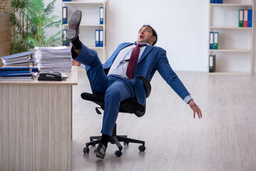 Young male employee unhappy with excessive work in the office