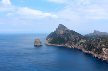 Fototapeta premium Beautiful landscape with a promontory jutting out into the sea. Soft clouds on the horizon.