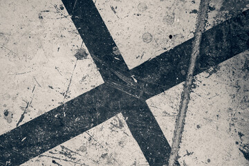 Fototapeta na wymiar Grungy dark stylised black cross on a flat damaged surface.