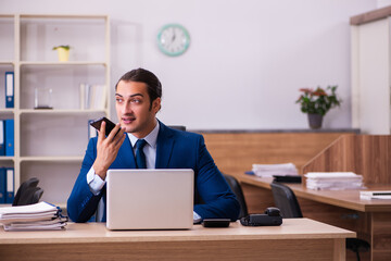 Naklejka premium Young male employee working in the office
