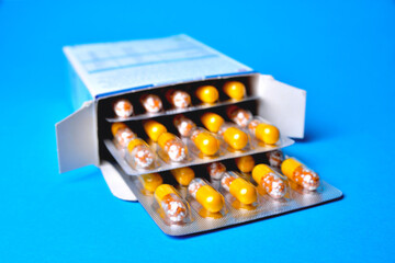 packaging with pills, capsules in blisters, blue background, close-up