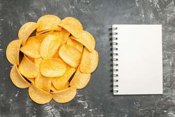 Table decoration with homemade potato chips on notebook on gray background