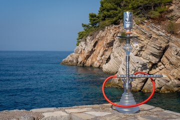 Hookah on the background of the blue sea and rocks.