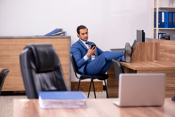 Young male employee sitting at workplace