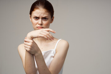 woman gesturing with her hands on a light background and white t-shirt model cropped view