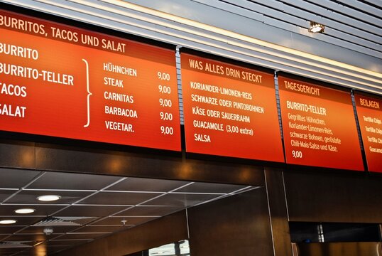 FRANKFURT, GERMANY: Chipotle restaurant menu in German. Chipotle items: burrito, burrito plate, tacos, salad, chicken, steak, carnitas, barbacoa, cilantro-lime-rice, black or pinto beans.