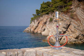 Hookah on the background of the blue sea and rocks.