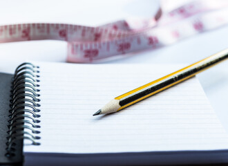 Reduce weight or weight loss concept to write down goals with inch tape in background