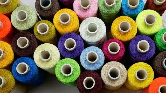 Lots of multicolored threads, Rows of spools for sewing machine and embroidery