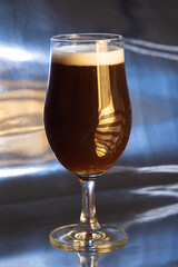 A glass of delicious-looking craft beer on a table, waiting to be consumed.