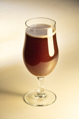 A glass of delicious-looking craft beer on a table, waiting to be consumed.