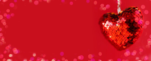 Hanging red sequins valentine heart on red background. Valentine's day banner. Flat lay, top view, copy space.
